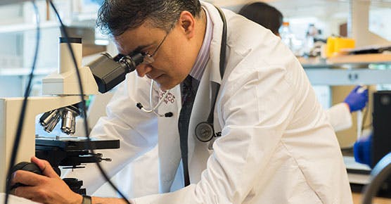 Researcher looking in microscope at UChicago Medicine