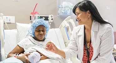 Lactation consultant Julita Ando offers breastfeeding support at a new mom's bedside