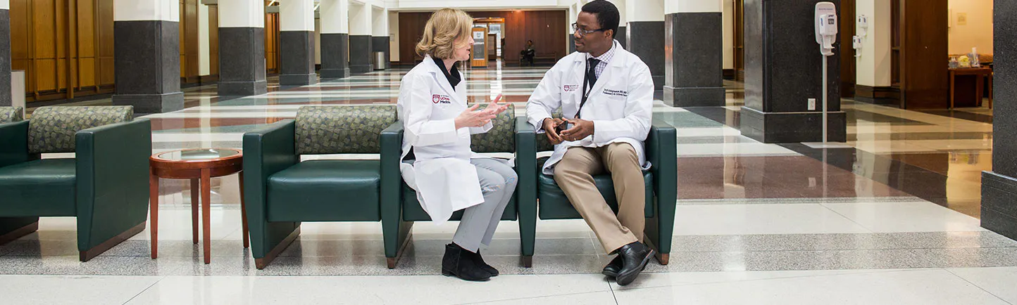 Two physicians speaking in the hospital lobby