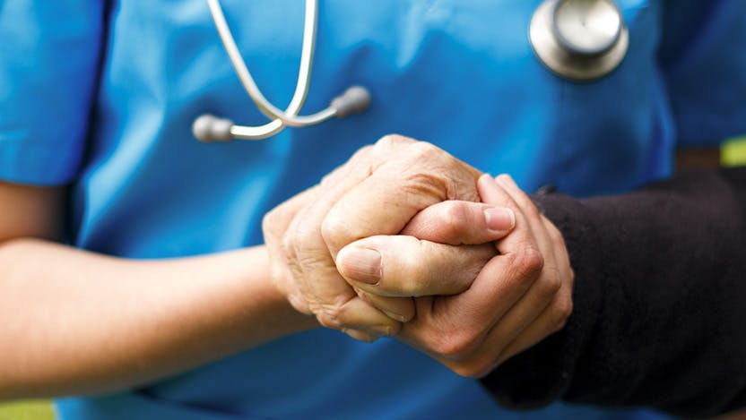 Image of primary care doctor talking to patient and holding their hand